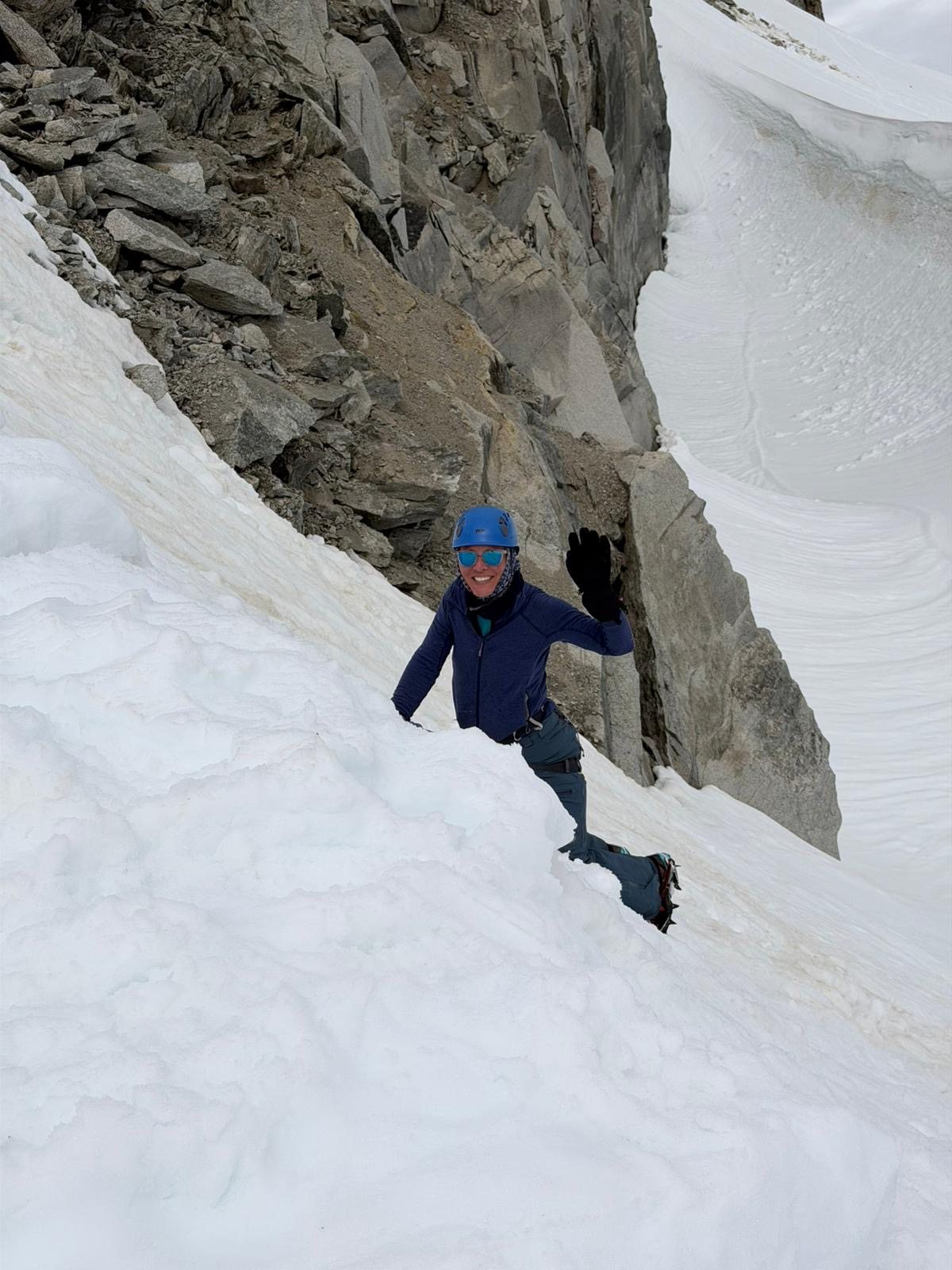 Erica Stanford waving from a snow slope on the Mont Blanc massif during crevasse rescue training — training for the Polar Dogs Antarctica Expedition